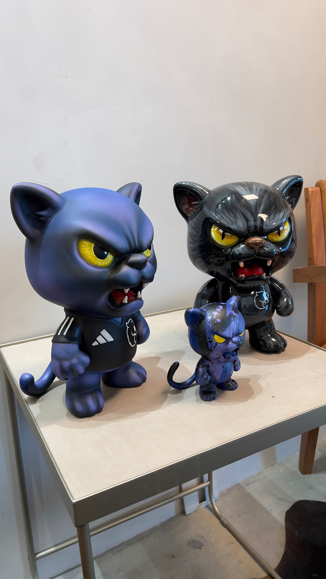 Três toy arts felinos vistos de outro ângulo, com detalhes das pinturas