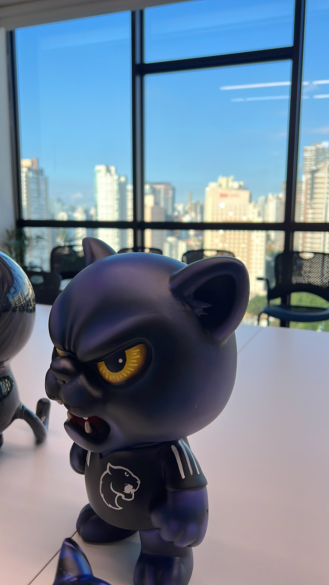 Toy art felino azul-escuro com olhos amarelos e símbolo de pantera no peito