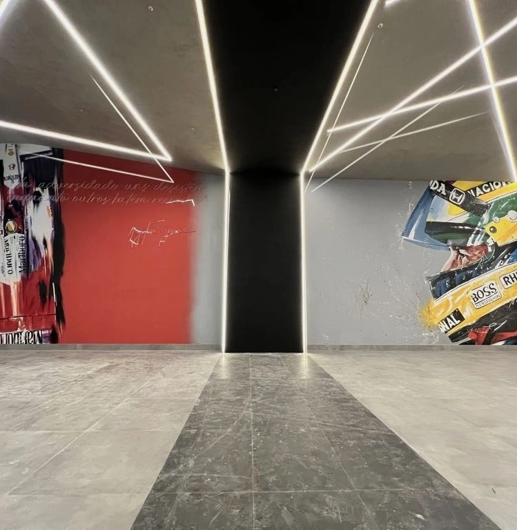Murais automobilísticos em hall com iluminação linear integrada à arquitetura